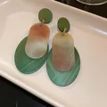 Close-up of vintage oval acrylic earrings featuring green and marble marble textures on a tray - Oval Layered Style / Green