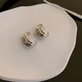 Close-up of minimalist silver hammered texture semi-circular hoop earrings for women. - Style 12 / Silver