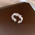 Nahaufnahme eines eleganten offenen Rings mit hohlem Blumenmuster in Silberoptik - Hohlblume / Silber