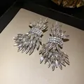 Exquisite close-up of sparkling crystal wing stud earrings on a luxury jewelry tray - Silver
