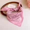 Detailed view of pink paisley print bandana hair accessory with silky satin finish - Pink