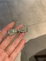 Close-up of a sparkling silver bow hair clip with rhinestones held in hand - 4. Duckbill Clip - Silver - Bow