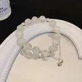 Primo piano di bracciale in occhio di gatto con campanello d'argento e luna su specchio. - Bianco