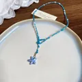 Elegante Nahaufnahme einer blauen Perlenhalskette mit Seestern-Anhänger auf einem Teller. - Stil 40 Blau Weiße Perlenkette Blauer Stern Anhänger