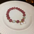 Close-up of pink strawberry quartz beads and white pearl charms on a ceramic plate - Double Pearl Pendant / Red/Pink