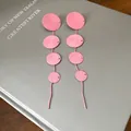 Detailed view of pink tiered disc tassel earrings with unique woven texture - Spiral Disc Tassel Style (HE27454) / Pink