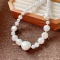 Close-up detail of a French style necklace featuring white pearls and gold cherry accents. - Necklace / 8-10mm / Gold-White