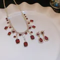Vue détaillée de l'ensemble élégant collier à franges et boucles d'oreilles strass doré - Ensemble 2 pièces carré rouge doré
