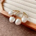 Close-up of elegant cherry-shaped gold earrings with white pearls in a wooden jewelry box - Earrings / Gold-White