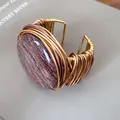 Primer plano detallado de un brazalete de resina vintage con tejido de alambre dorado - Brazalete abierto redondo / Oro y Café