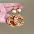 Detailed close-up of handmade bohemian rattan hoop earrings featuring straw beads and wood accents - 8# Steel Earring Post-Brown-Round