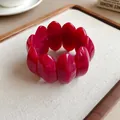 Dettaglio dei segmenti ovali in acrilico marmorizzato rosso su un bracciale chic - Rosa Rosso