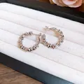 Gros plan de boucles d'oreilles créoles texturées en argent irrégulier dans un coffret - Créole (Tige en Argent) / Argent
