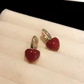 Macro detail of red heart hoop earrings on a beige velvet jewelry tray - 70# Ear Buckle - Red - Heart (Real Gold Plated)