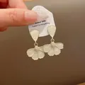 Primo piano dettagliato di eleganti orecchini a fiore in smalto bianco e bordo oro - Oro-Bianco