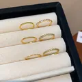 Primo piano di sei anelli placcati oro con zirconi in un portagioie - Set da 6 Pezzi / Oro