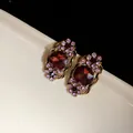 Vue détaillée de boucles d'oreilles vintage avec cristaux rouges et strass violets dorés - Boucles d'oreilles / Or-Violet