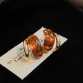 Close-up of retro geometric gold-plated earrings with amber resin detail on card - Coffee Brown (Real Gold Plated Silver Pin)