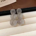 Makroaufnahme von silbernen hohl gewebten Dreifach-Kreis-Ohrhängern auf Schmucktablett - Dreifach Runde Hohl-Ohrstecker (Silber)