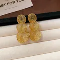 Makro-Detail eleganter goldener Dreifach-Kreis-Filigran-Ohrringe auf weißem Display - Dreifach Runde Hohl-Ohrstecker (Gold)