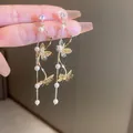 Elegant gold butterfly tassel earrings with white pearls and sparkling crystals - Gold Pearl Butterfly Tassel