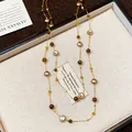 Close-up of retro beaded sweater chain with irregular champagne and brown beads. - Coffee and Gold