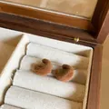 Macro detail of elegant brown flocked C-shaped earrings with S925 silver needles inside a box - Brown