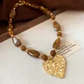 Vintage amber marbled bead necklace featuring a large hammered gold heart pendant - Coffee
