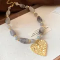 Vintage irregular marble bead necklace featuring a textured gold-tone heart pendant - Transparent Marble Color