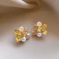 Elegant flower stud earrings with yellow petals and pearls on a beige silk background - Yellow-White