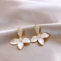 Elegant gold-tone flower earrings with white shell petals and sparkling cubic zirconia stones - Gold-White