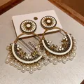 Detailed view of Bohemian ethnic earrings with sunburst motif, gold bird accents, and pearls. - Enamel Sun Motif Silver Post Style / Gold-White