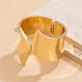 Close-up view of a high-shine gold asymmetric metal cuff bracelet with a hinged closure. - 5# Polished Small Style (HB3406)