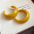 Dettaglio di orecchini a cerchio a forma di C in resina giallo brillante lucida - Giallo