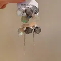 Detailed close-up of gold-plated silver needle flower tassel earrings with crystal center - Silver