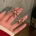 Detailed macro shot of red firework stud earrings featuring central pearls and sparkling zircons - Silver Post Fireworks Style / Gold-Red