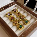 Detailed view of vintage gold earrings with multi-colored square and round gemstones - Geometric Tassel Style / Colorful