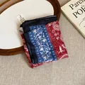 Detail of a vintage floral print bandana folded on a rustic wooden tray and book. - Red Blue Patchwork Paisley Style (2#)
