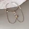 Vue détaillée des breloques papillon en métal argenté et chaînes - Manchette de bras / Argent