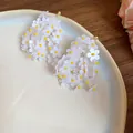 Orecchini eleganti a grappolo di fiori bianchi con perline gialle su un piatto - Fiore a Grappolo Bianco