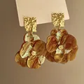 Close-up of elegant flower earrings with amber marble pattern and golden hammered studs - Style 4