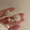 Detailed macro shot of elegant floral pearl earrings with shimmering crystal accents. - Style 8