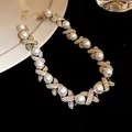 Detailed view of French vintage palace style pearl necklace with rhinestone X-links - Necklace / Gold-White