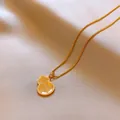 Elegant gold-finished hulu gourd pendant necklace resting on champagne silk fabric - Textured Gold Gourd Style