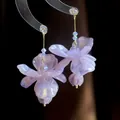Eleganti orecchini pendenti a fiore in resina lavanda con cristalli luminosi e dettagli dorati - Goccia a Fiore Lunga Viola