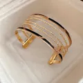 Detailed macro view of a gold multi-layer cuff bracelet with chic leopard print leather - Gold Leopard Print