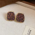 Détail de boucles d'oreilles vintage à imprimé léopard floqué avec bordure dorée - Modèle Trapézoïdal