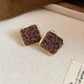 Gros plan de boucles d'oreilles léopard rétro avec monture en métal doré - Géométrique