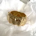 Detailed view of the irregular pleated texture on this gold-colored wide cuff bracelet. - Glossy Irregular Wrinkled Style / Gold