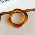 Detailed view of vintage amber acrylic bangle with irregular wave design and marble pattern - Amber Brown